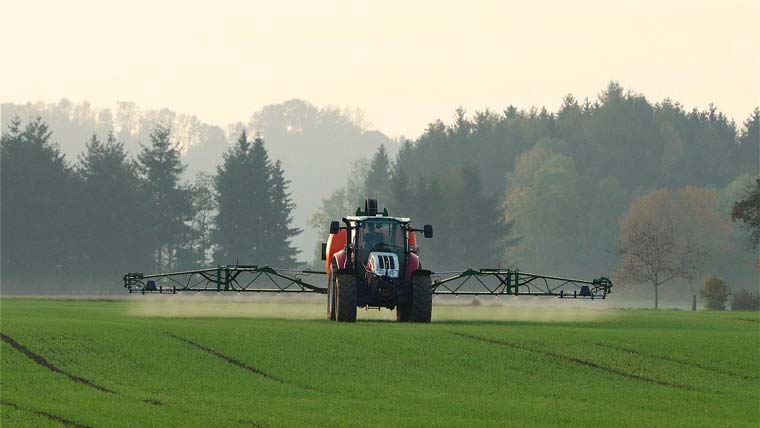 Agriculteur pulvérisant un traitement sur son champ